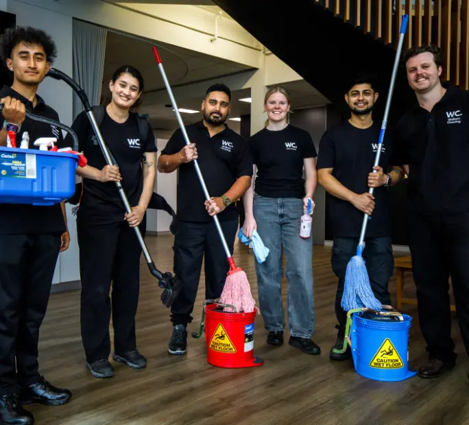 Walker's Cleaning professional team in uniform with commercial cleaning equipment and mops in Sydney office