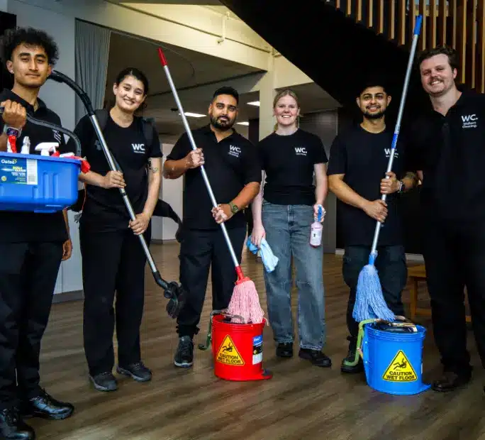 Walker's Cleaning professional team in uniform with commercial cleaning equipment and mops in Sydney office